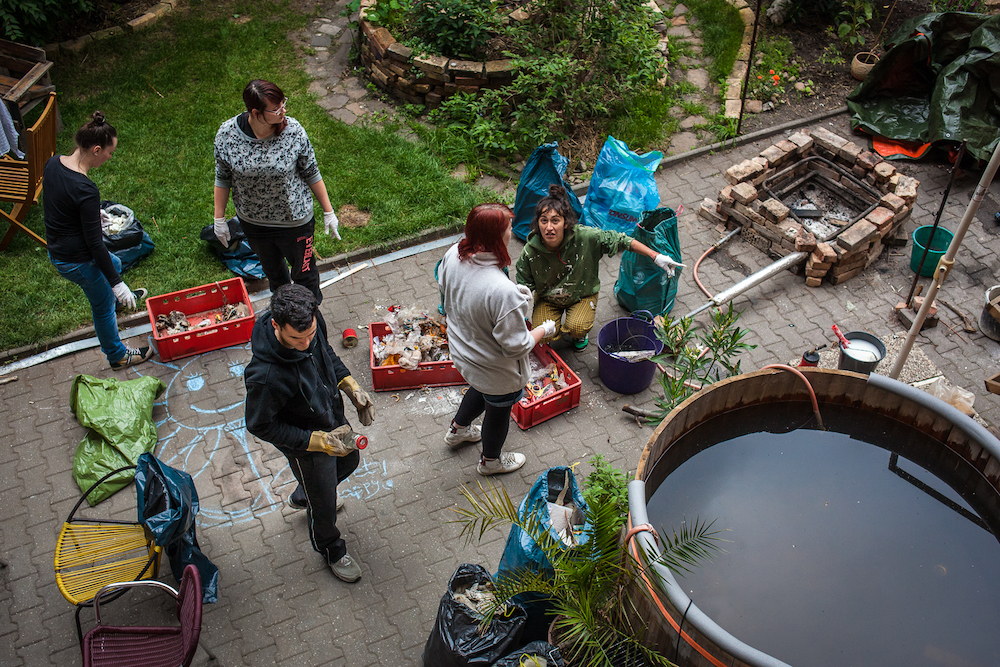 A casa di Suzie, i membri della comunità partecipano alle pulizie di primavera davanti allo “hippie-jacuzzi”.