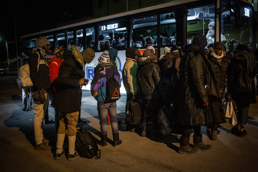 Refugees board the coach which will take them to the last town before the French border.