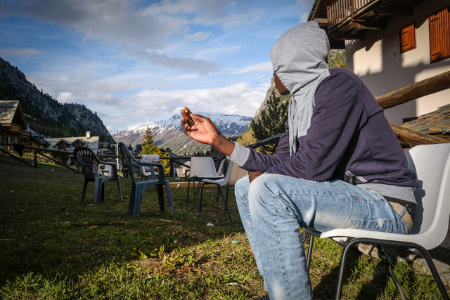 In Claviere, a refugee looks at the mountains while waiting for the time to depart.