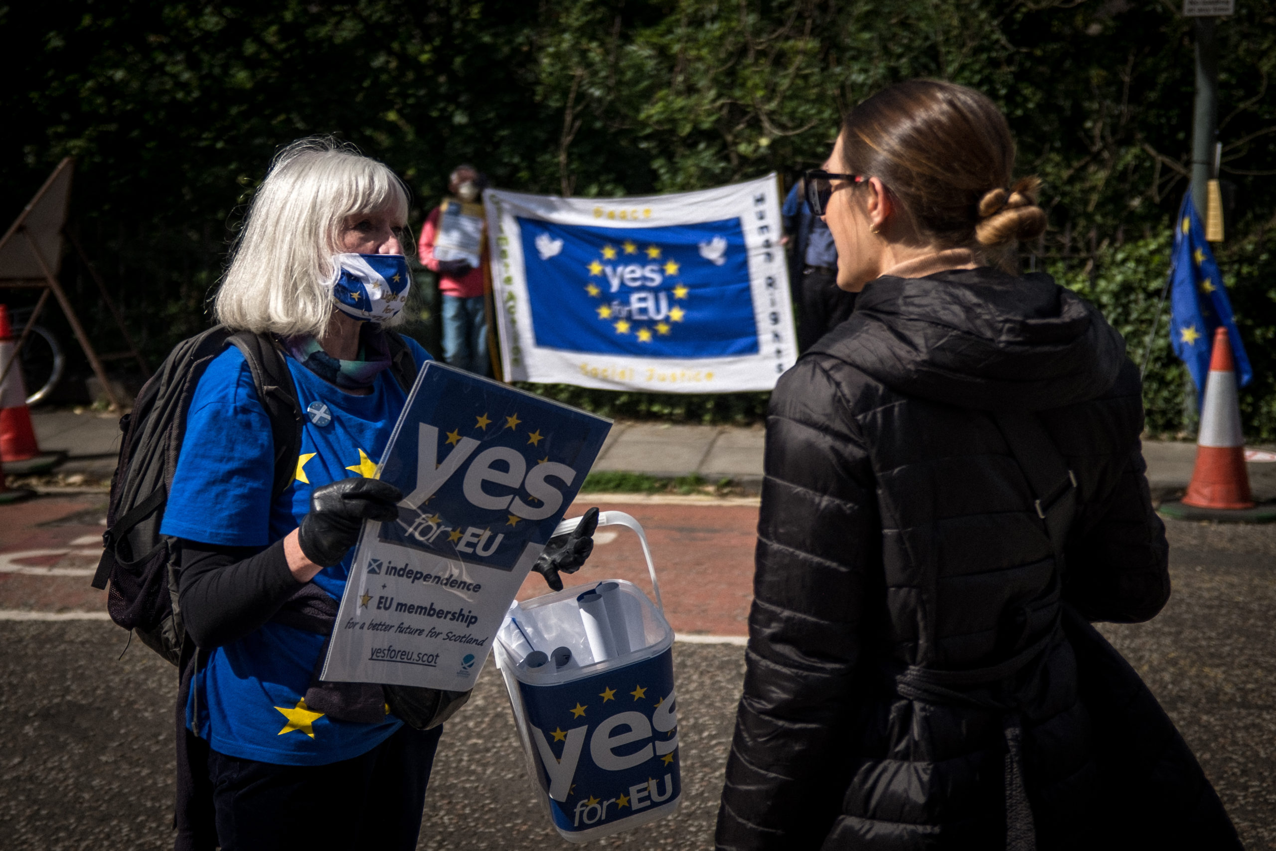 Une militante de YES for EU discute avec une passante pour promouvoir l'indépendance et un retour dans l'UE.