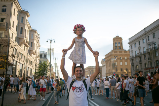 Ein Mann mit seiner Tochter auf der Praspiekt Niazaliežnasci, der Hauptstraße von Minsk. August 2020.