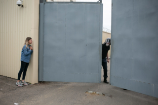 Una donna parla con un poliziotto mentre chiude i cancelli della prigione in via Akrestsin. Minsk agosto 2020.