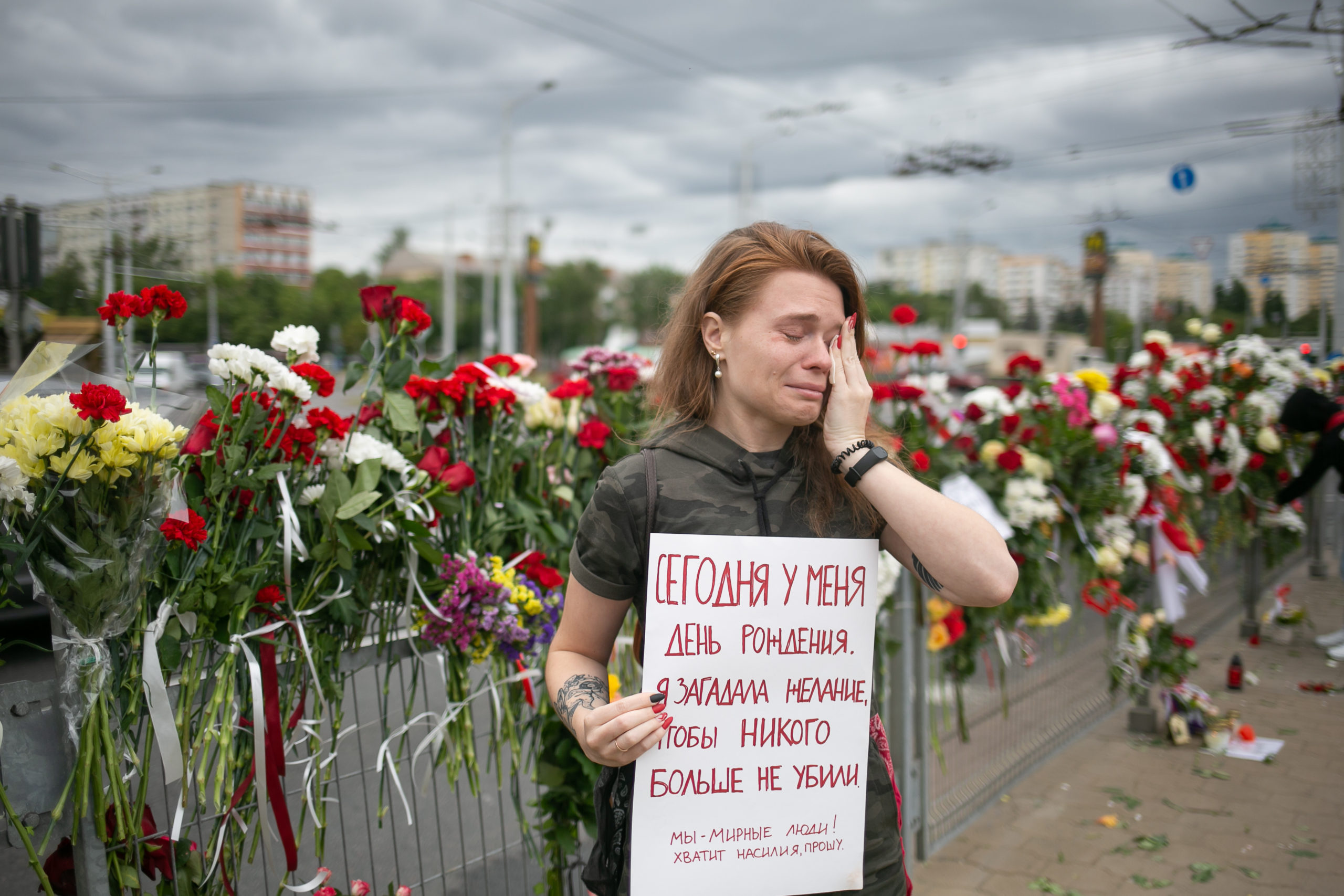 Eine junge Frau weint in der Nähe des beliebten Denkmals zu Ehren des von der Polizei ermordeten Demonstranten Aleksandr Taraikovsky. Auf ihrem Plakat steht: „Heute ist mein Geburtstag. Ich wünsche, dass sie niemanden mehr töten. Wir sind friedliche Menschen! Keine Gewalt mehr, ich bitte Sie“. Minsk, August 2020.