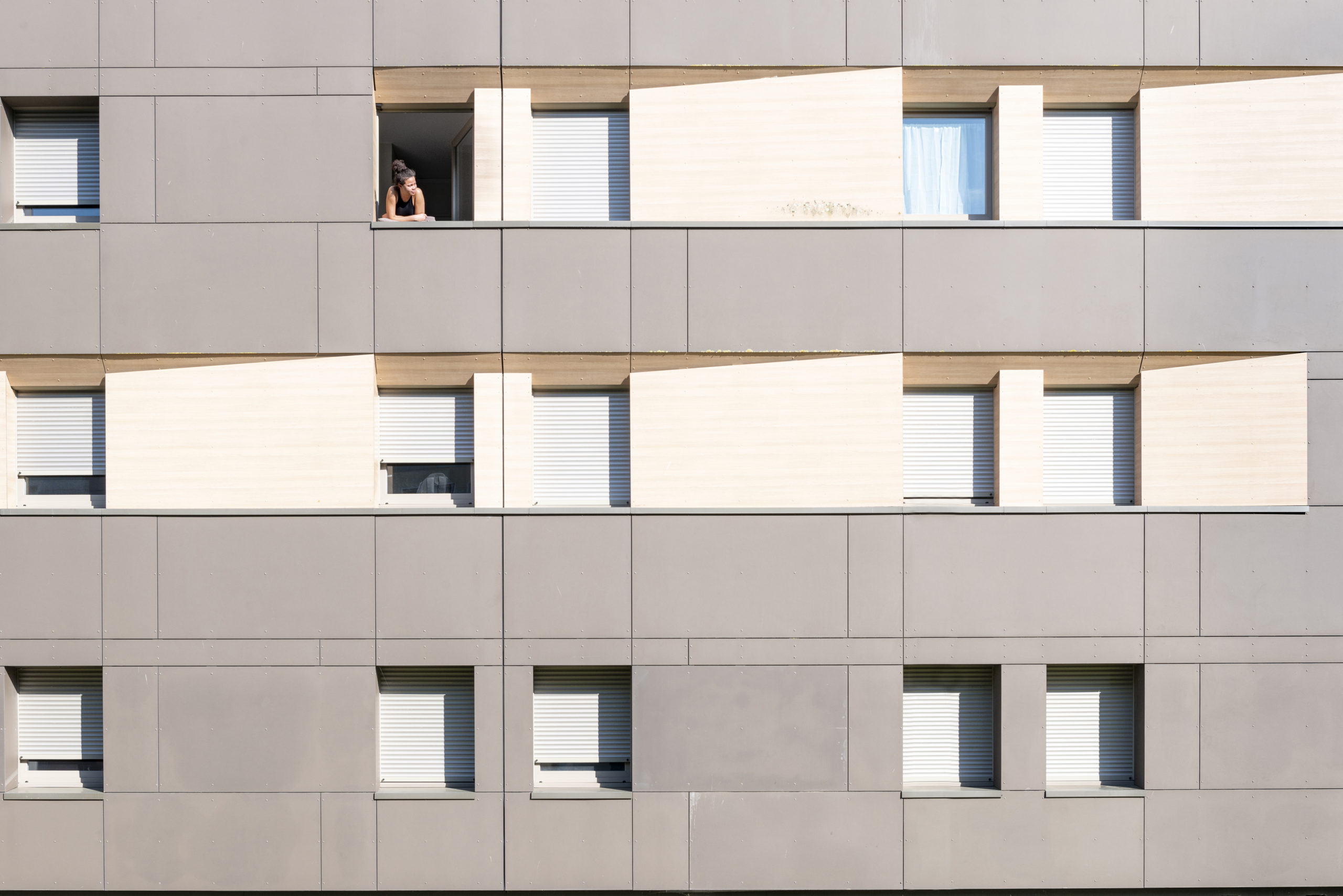 Une étudiante confinée dans une résidence universitaire de Poitiers prend l'air depuis sa fenêtre. De nombreux appartements semblent vides, les étudiants étant retournés dans leurs familles.