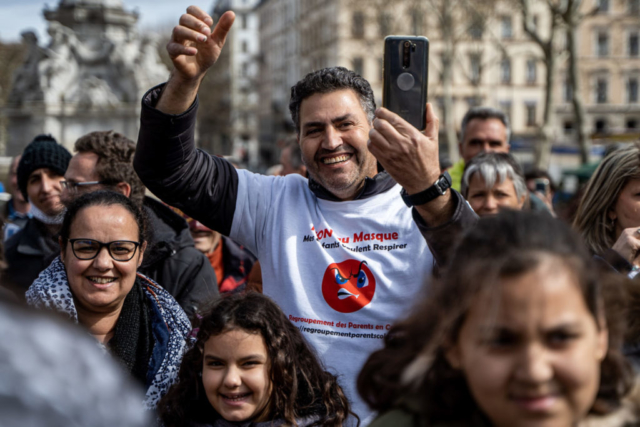 Manifestazione “Libert Air”.  Un manifestante indossa una maglietta con la scritta “No alla maschera, I miei figli vogliono respirare”. Lione, Francia, 13 marzo 2021.
