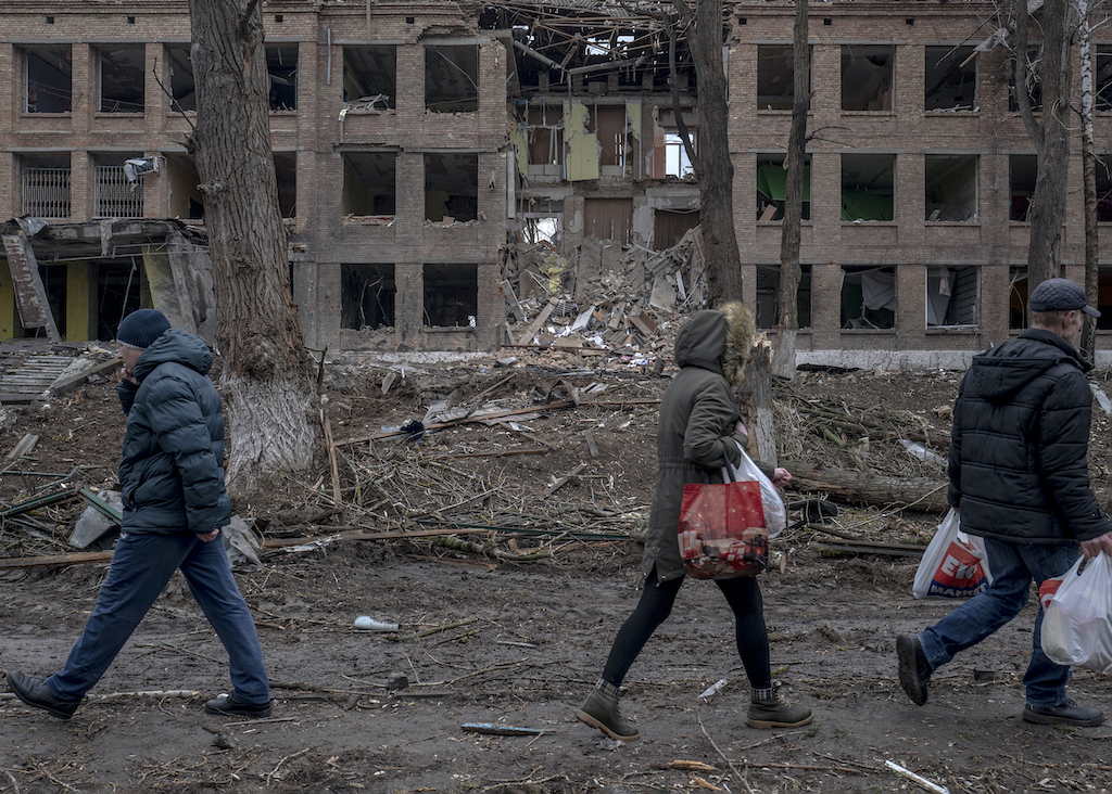Vasylkiv, au sud de l’oblast de Kiev, le 3 mars. Des habitants marchent près d’un lycée détruit par une frappe russe.