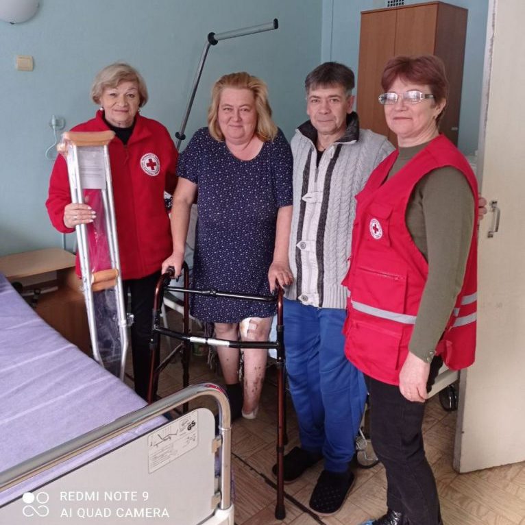 In a hospital ward, Natalia is relearning to walk with the support of her husband Oleksandr and Red Cross workers. | Photo: Orikhiv district organisation of the Red Cross Society
