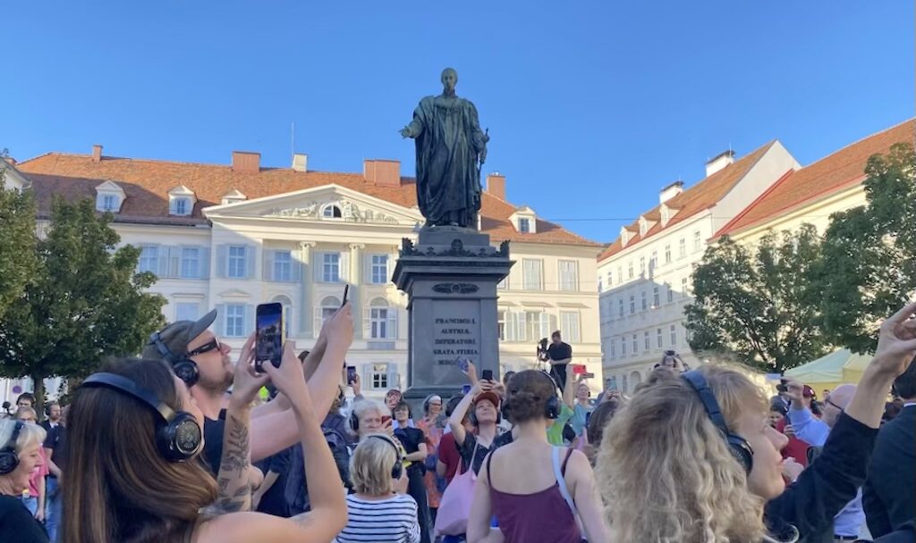 Performance sonore immersive pensée par LIGNA, "Freedom Square" (2025), célébrant l'ouverture de la saison du Steirischer Herbst. La séquence requestionne la notion de "liberté" sur cette place ainsi nommée, mais plusieurs fois rebaptisée au fil de l'histoire. | Photo: ©ABK