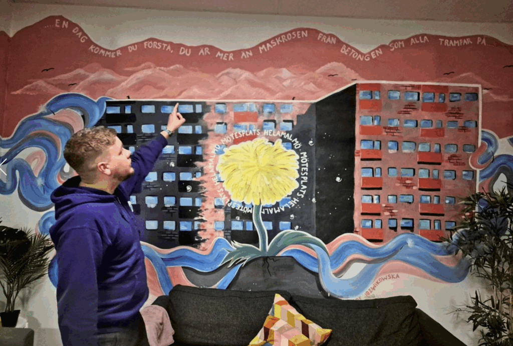 Robin Pihl stands in front of a colourful mural created by a young person at the youth centre. l Photo: DER STANDARD/B. Blei